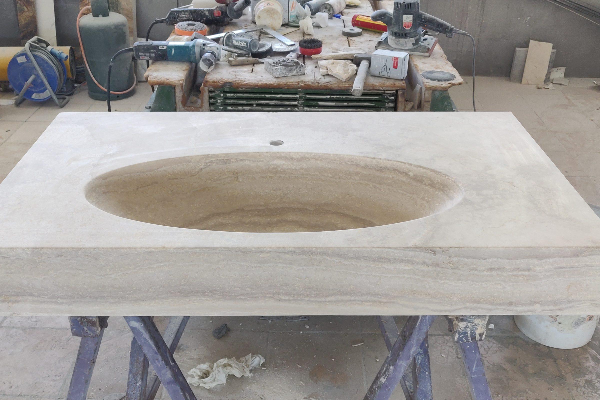 Lavabo in travertino scavato nel pieno, sul banco del laboratorio