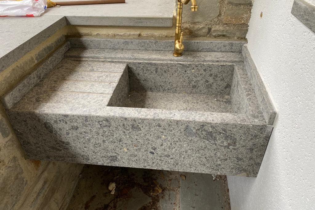 Lavello da giardino in pietra grigia con rubinetto in ottone