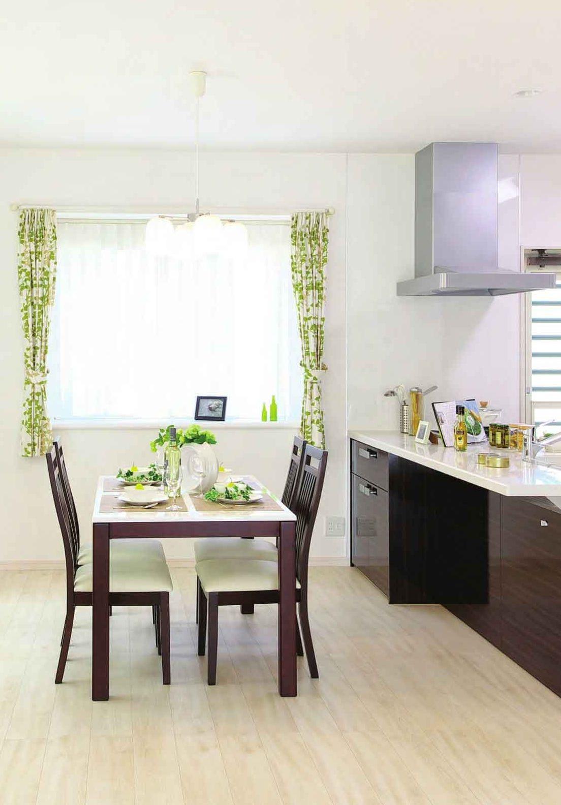 Cucina luminosa con isola scura e piano in pietra chiara