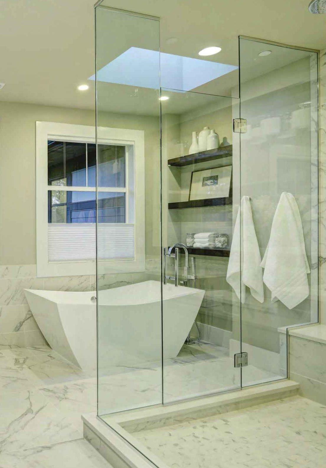 Bagno in marmo bianco con vasca freestanding e doccia in vetro