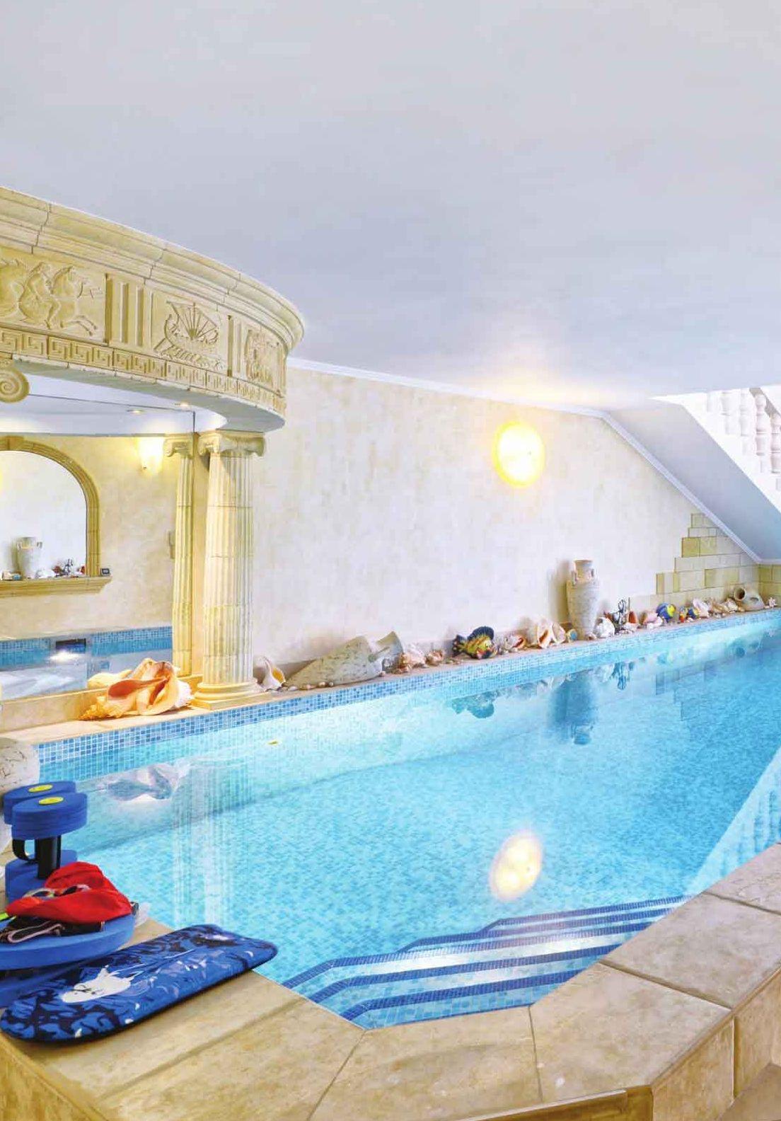 Piscina interna con bordo in pietra e colonne