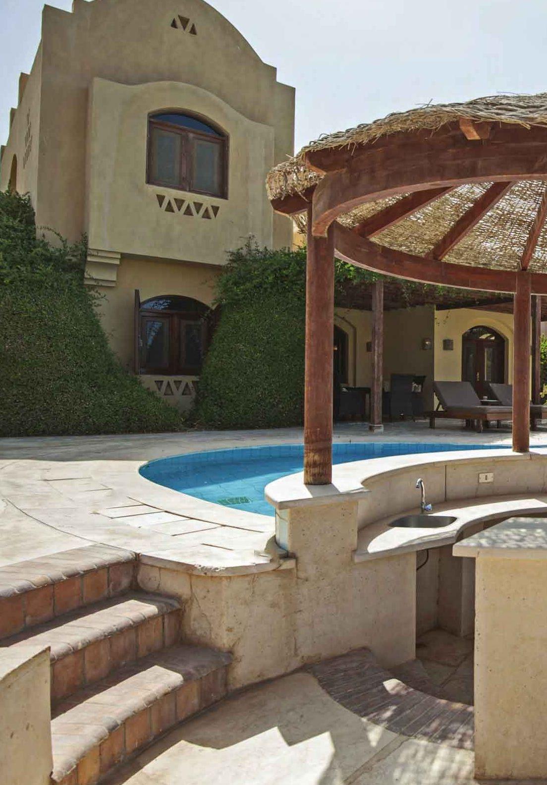 Piscina esterna con scalini in pietra e pergola