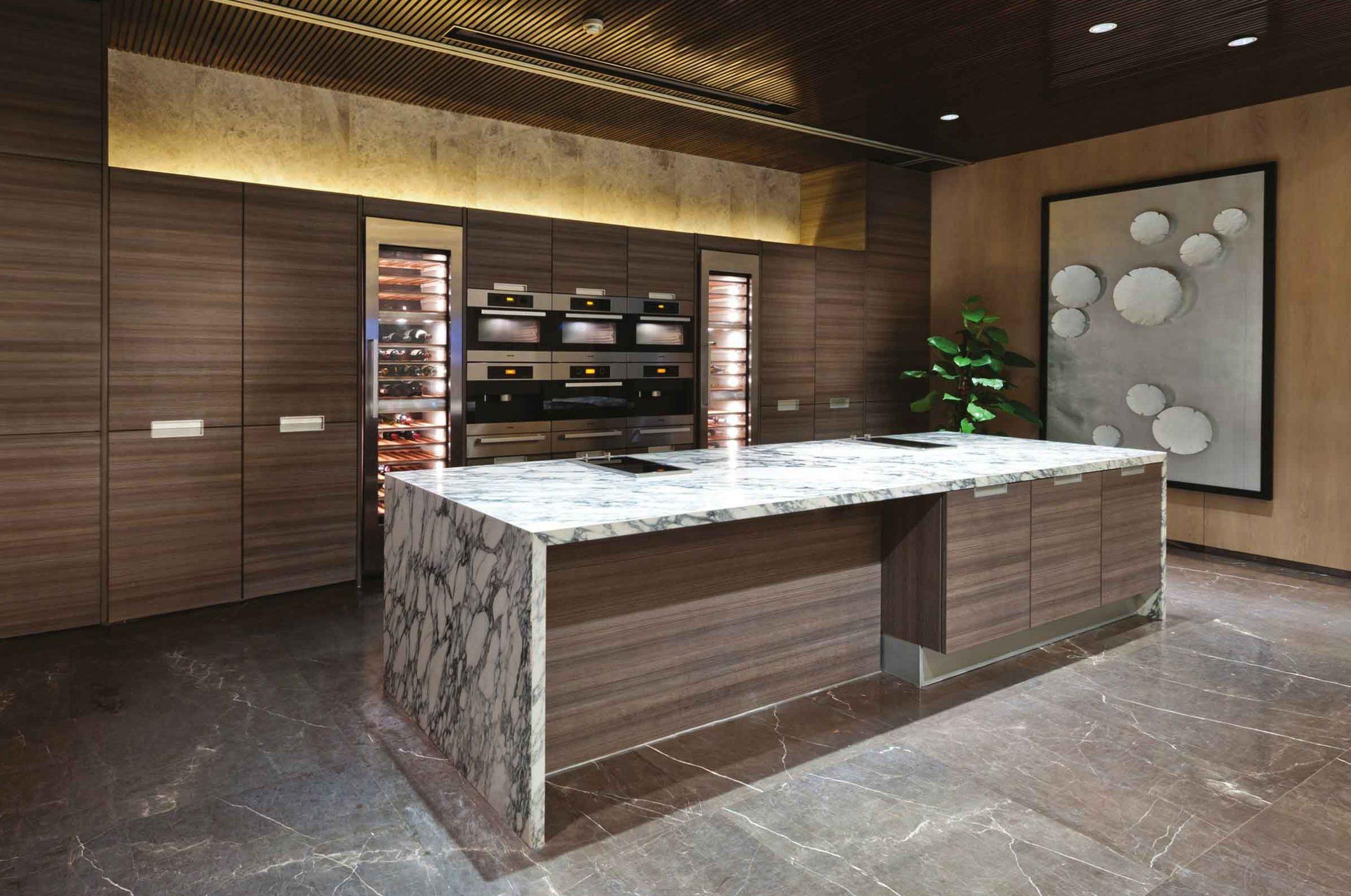 Isola cucina monolitica in marmo grigio venato e boiserie in noce