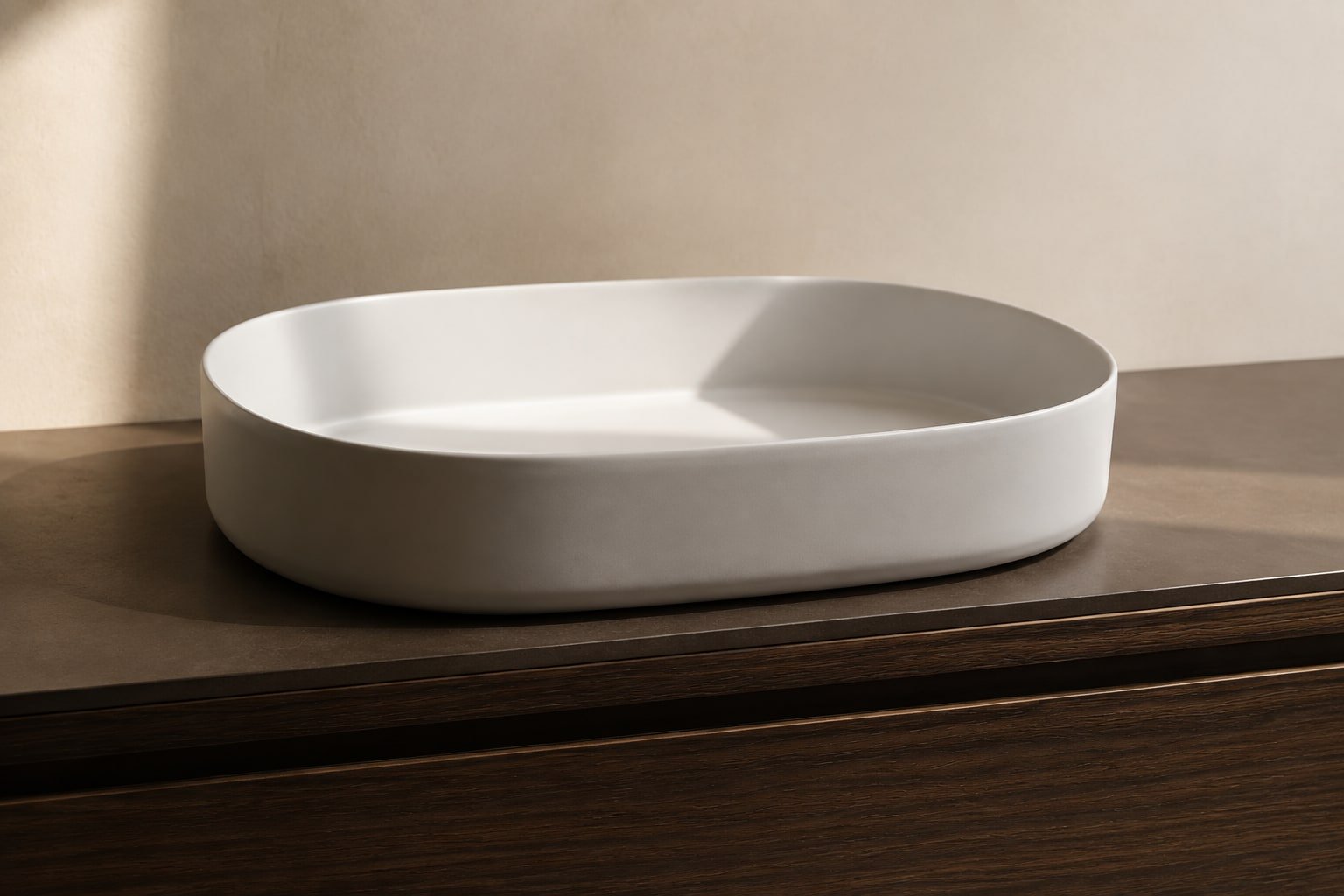 Lavabo ovale bianco su mobile in legno scuro