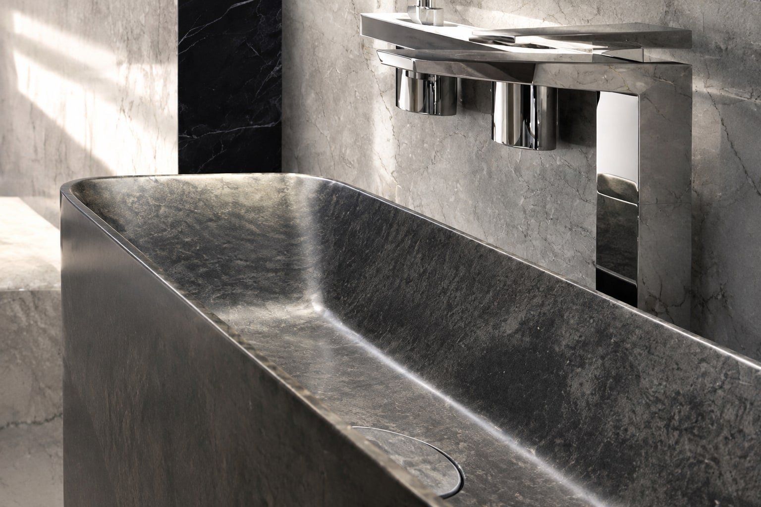 Lavabo rettangolare scavato in pietra scura con rubinetteria cromata