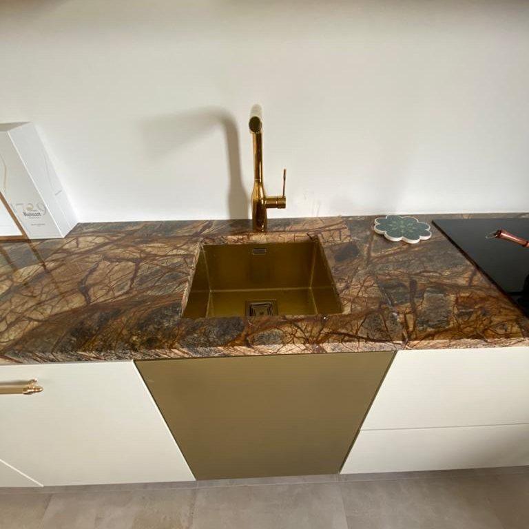 Piano cucina in marmo bruno a venature ramificate con lavello in ottone
