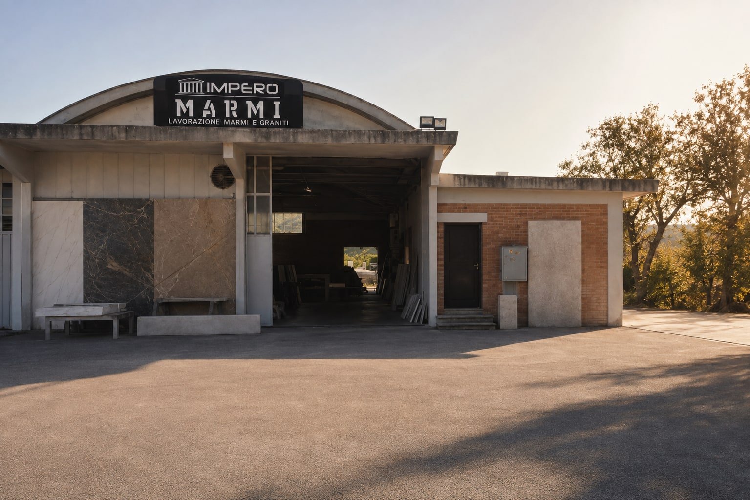 La facciata del laboratorio Impero Marmi con l'insegna, vista dal piazzale