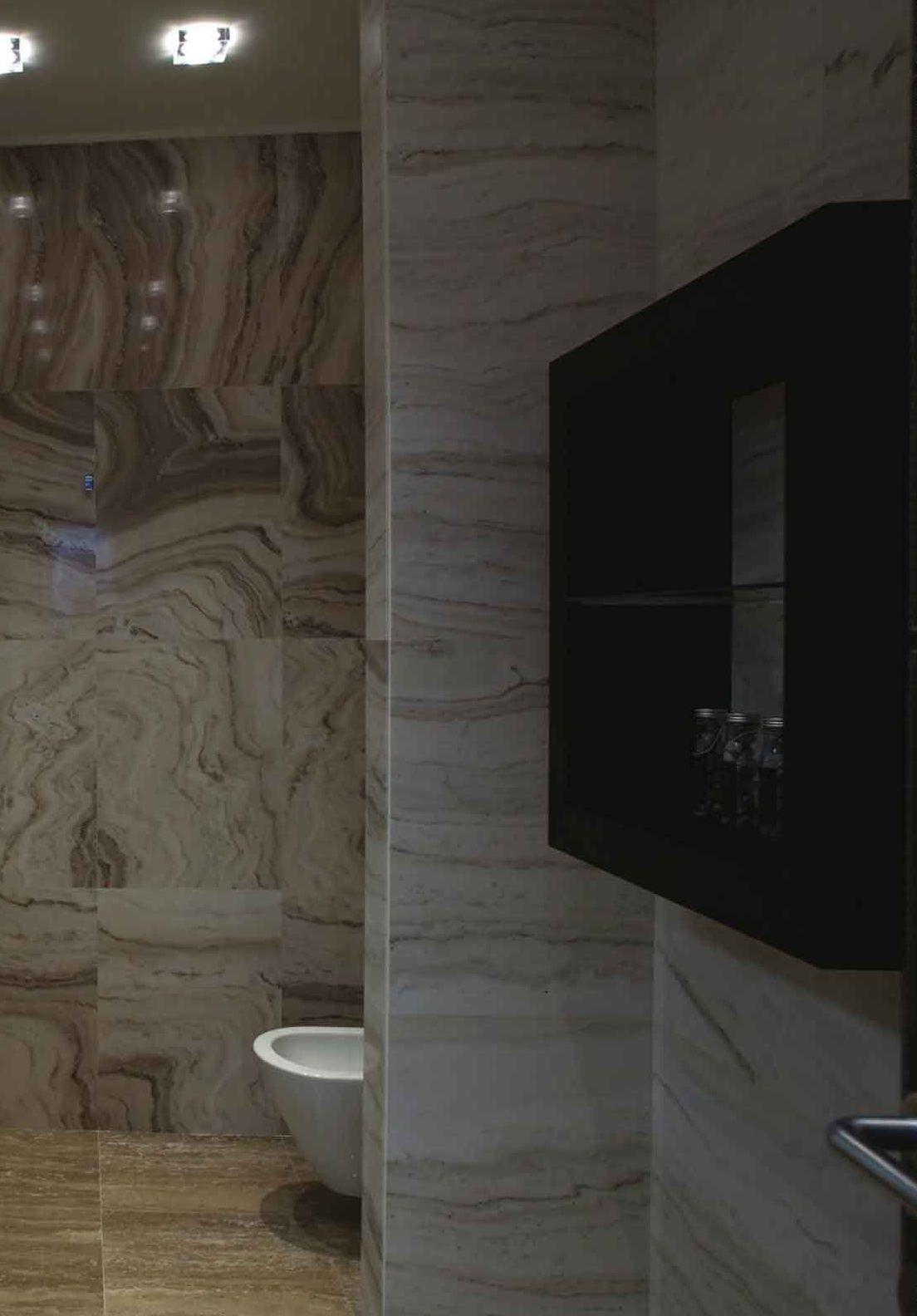 Bagno rivestito in marmo beige venato a tutta altezza