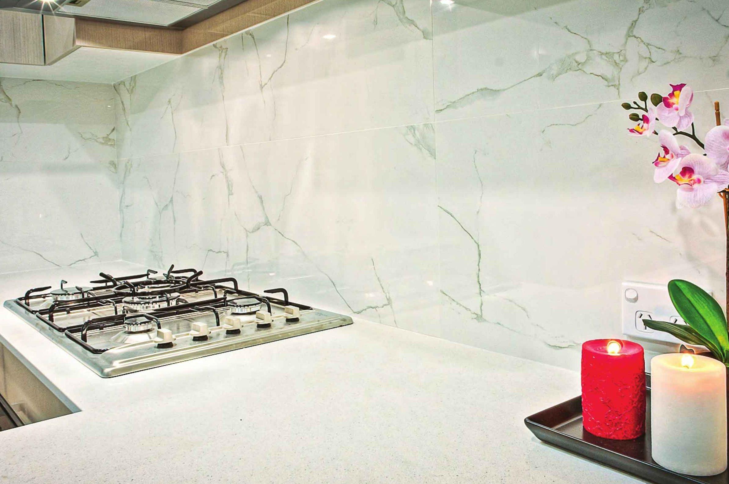 Alzata e piano cucina in marmo bianco venato con piano cottura a filo